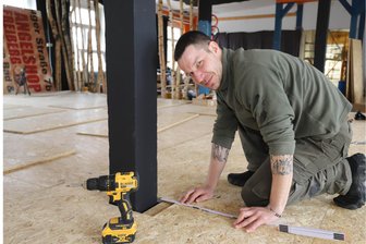 Nach Großbrand in Freiberg: Wie eine Sportakademie ihre neue Heimat fand - Marcus Kuckenburg beim Verlegen des Bodens im großen Trainingsraum seiner Freiberger Kampfsportschule.