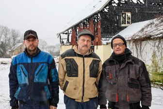 Nach Großfeuer auf Dreiseitenhof im Erzgebirge: Nachbarn stehen Familie zur Seite - Die Nachbarn Achim Schneider (rechts) und Benjamin Huster haben Michael Becher in ihre Mitte genommen. Sie wollen ihm zur Seite stehen nach dem Brand, bei dem zwei Gebäude des Dreiseitenhofes in Wildbach zerstört wurden.
