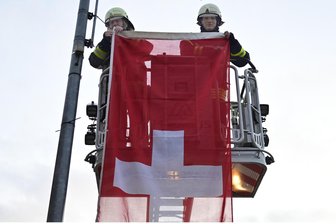 Nach Kritik beim Sommer-Grand-Prix: Klingenthal zeigt wieder Flagge - Clemens Schlott (rechts) und Toralf Wolff von der Wache 1 der Freiwilligen Feuerwehr hängen die Fahne der Schweiz auf.