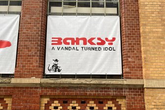 Nach Kunst-Diebstahl aus Banksy-Ausstellung: Kripo ermittelt - Das Foto zeigt ein Plakat an der Markthalle, in der die Banksy-Ausstellung aktuell zu sehen ist.
