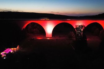 Nach „mega“ Licht-Premiere an Autobahnbrücke im Vogtland - Jetzt rückt schon Weihnachten in den Blick - Premiere mit Licht und Drohne. Die Aufnahme zeigt die Autobahnbrücke im Weißensander Rotweiß und das Festzelt.