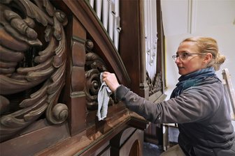 Nach Sanierung: Glauchauer Jehmlich-Orgel erklingt wieder - Kirchenmalerin und Restauratorin Nadina Leunißen vom Malerfachbetrieb Röhner GmbH arbeitet die Holzverkleidung der Orgel in der Glauchauer Lutherkriche auf.