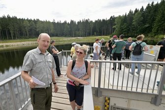 Nach Sanierung von Heiligem Teich im Erzgebirge: Darf diesen Sommer hier gebadet werden? - Revierförster Michael Melzer (l.) am Heiligen Teich im Gespräch mit Denise Copp.