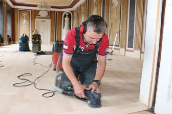 Nach sieben Jahren Wartezeit: Parkettleger sanieren Fußboden im Schloss Leubnitz - Theo Machold von Parkett Schulz aus Plauen bei der Arbeit im Weißen Saal.