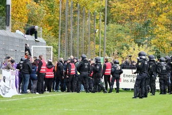 Kurz vor Schluss stürmten Anhänger des FC Erzgebirge Aue in Riesa aus dem Gästeblock.