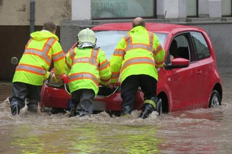 Nach Starkregen: Land unter in Aue - Nach dem Unwetter steckte ein Fahrzeug in den Fluten auf der Auer Bahnhofstraße fest. Rettungskräfte der Feuerwehr schoben das Auto aus dem Wasser. 
