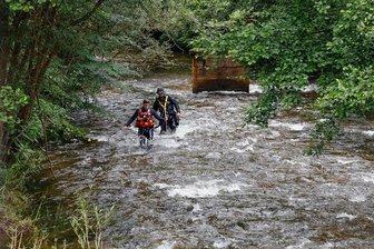 Nach Sturzflut in Steinbach: Polizeitaucher suchen im Erzgebirge nach vermisstem Mann - Polizeitaucher - der erste des Trupps in spezieller Fließretter-Ausrüstung - und mit einer Sicherungsleine verbunden, suchen bei Niederschmiedeberg die Preßnitz ab. 