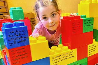 Nach Trägerwechsel von Auer Kita: Kinderwünsche an den neuen Betreiber - Ein Fundament aus Legosteinen symbolisiert die Übernahme der Auer Kindertagesstätte "St. Nikolaus" durch die Diakonie. Levia Tautenhahn und die anderen Kinder durften Wünsche äußern, die auf den Steinen stehen.