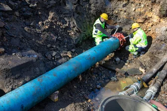 Nach Trinkwasser-Havarie im Vogtland: Rohrtausch im Flussbett der Weißen Elster erfolgt - Frank Ebisch (links) und Niklas Leiner zurren die Kupplungsverbindung nach Austausch des defekten Rohrs fest.