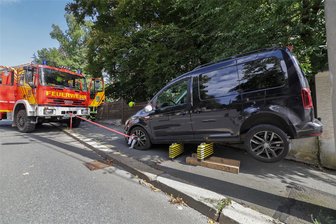 Nach Unfall mit schwerverletztem Kind im Villenviertel in Glauchau: Welches Missgeschick einer Ersthelferin in der Aufregung passiert ist - Der VW Caddy wird mit einem Seil am Wagen der Ortsfeuerwehr aus Niederlungwitz gesichert.