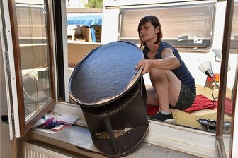 Nach Unwetter in Oelsnitz: Familie bangt um eigenes Haus - Josefine Lötzsch räumt aus ihrem Haus die zerstörten Möbel durch ein Fenster aus. Die untere Etage des Hauses an der Falkensteiner Straße in Oelsnitz wurde bei dem Unwetter am 13. Juli vom Starkregen überschwemmt.