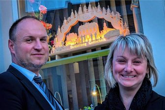 Nach Weihnachten ist vor Weihnachten: Warum im Mittleren Erzgebirge noch Schwibbögen leuchten - Susan und Marcel Uchlier haben im Schaufenster ihres Bestattungsinstitutes einen leuchtenden Schwibbogen. 