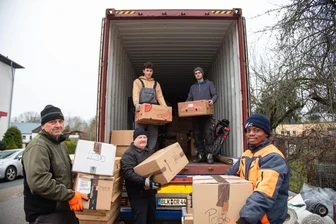 Nähmaschinen für Afrika: Wie Menschen aus dem Vogtland Träume verwirklichen - Freiwillige Helfer des Vereins Kinderhilfe Westafrika verladen Hilfsgüter. Mit Stanislas Houansou (rechts) ist ein Freiwilliger aus Benin dabei.