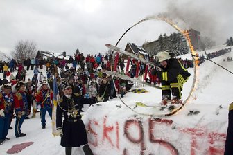 Eric Scheunert von der Oberwiesenthaler Feuerwehr beteilgt sich mit einem waghalsigen Sprung durch einen brennenden Reifen am traditionellen Narrenspringen.