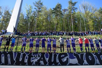 Nazarovs Doppelschlag beschert Erzgebirge Aue Heimsieg über Osnabrück - Aues Spieler feiern nach dem Spiel mit Fans, die vor dem Stadion im Wald stehen.