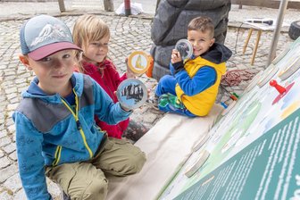 Neu für Familien im Erzgebirge: eine Abenteuerreise mit Greifi durch die Greifensteinregion - Lio, Marie und Sirius (von links) haben nach dem Besuch beim Räuber Hotzenplotz auf der Freilichtbühne das neue, etwa 1,40 Meter große Spiel vor der Tourist-Information an den Greifensteinen ausprobiert. Dort können die Kinder die Ausflugsziele von Greifis Abenteuerreise schon mal im Vorab kennen lernen.