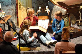 Neuapostolische Kirche in Plauen überrascht mit eigenem Weihnachtsmusical - Drei Kinder entdeckten in dem Weihnachtsmusical auf einem Dachboden ein großes Buch und stöbern darin, bis sie spannende Geschichten fanden.