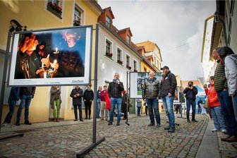 Neuauflage der Oederaner Perspektiva startet mit Pressefotos - Mit mehreren Aufnahmen von "Freie Presse"-Fotografen startete am Samstag die Oederaner Freiluft-Fotoschau Perspektiva in die nächste Runde. Moderiert wurde die Veranstaltung vom Leiter der Volkskunstschule Rolf Büttner (Bildmitte), der mit "Freie Presse"-Fotochef Uwe Mann (Bildmitte, rechts neben Büttner) die Bilder vorstellte. Marcel Schlenkrich (Bildmitte, rechts neben Mann) ist auf der Ausstellung mit zwei Motiven vertreten.