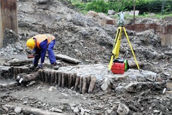 Neubau der Schwarzbachbrücke in Kunnersdorf: Archäologen sichern Reste von altem Brückenfundament - Sehr gut zu erkennen: Das historische Brückenlager aus Bruchsteinen, die mit Holzpfählen eingefasst sind.