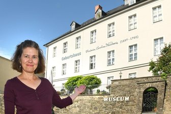 Neuberin-Museum Reichenbach - ein Patient mit Potential - Museumsleiterin Martina Bundszus vor dem Geburtshaus von Friederike Caroline Neuber, in dem sich das Neuberin-Museum befindet.