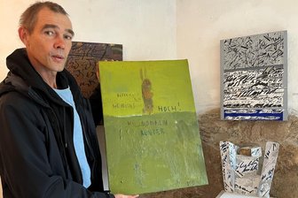 Neue Ausstellung im Kunstkeller Annaberg: Was Besucher zum Thema „Schrift-Bild“ erwartet - Unter dem Titel „Schrift-Bild“ wird bis Mitte September eine Ausstellung im Kunstkeller Annaberg gezeigt. Im Bild dessen Leiter Jörg Seifert, der eine Arbeit von Osmar Osten in den Händen hält.