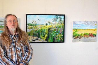 Neue Ausstellung in Reichenbachs kleinster Galerie - Peter Wieting vor einigen seiner Bilder im Foyer der Zahnarztpraxis Kirsten.