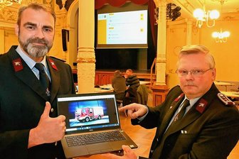 Neue Fahrzeuge für die Feuerwehren in Hainichen - Jörg Nollau (r.) und Norman Teuchert zeigen ein Bild des Löschgruppenfahrzeugs LF 10. 