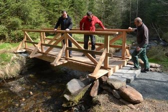 Neue Fußgängerbrücke zur Göltzschtalbastei steht - Bürgermeister Ralf Kretzschmann und die Bauhof-Mitarbeiter Tilo Möckel und Timo Pöhler schauen sich die neue Fußgängerbrücke an. 