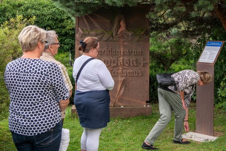 Neue Gedenktafel nennt KZ-Opfer beim Namen - Besucher der Einweihung legen gemäß jüdischer Tradition Steine am Fuß der Gedenkstätte ab. 
