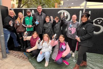 Neue Graffitiwand am Reichenbacher Jugendzentrum „Lila Pause“ eingeweiht - OB Henry Ruß (hinten 4. v. l.) ließ es sich nicht nehmen, bei der Einweihung der Graffitiwand selbst zu sprühen. Max Gollmann (3. v. l.) gab den jungen Künstlern Hilfestellung.