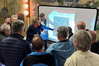 Neue Hochspannungsleitung bei Kirchberg: Wo sie verlaufen könnte und welche Orte betroffen sind - Bürger umlagern beim Infoforum in Obercrintz die Präsentation zur neuen Stromtrasse.