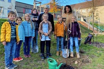 Neue Kinderräte setzen ein Zeichen - Der Kinder-Gemeinderat beim Apfelbäumchen-Pflanzen. In der Bildmitte Kinderbürgermeisterin Luana Pitzler (vor Bürgermeisterin Marion Dick), rechts im Bild Gemeinderätin Melanie Dommaschk. 