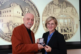 Neue Münze aus dem Erzgebirge: Ehrenfriedersdorfer Exemplar ziert besonderes Stück Bergbaugeschichte - Helmut Herholz, Vorsitzender des Vereines Freiberger Münzfreunde, übergibt Ehrenfriedersdorfs Bürgermeisterin Silke Franzl eine der ersten Medaillen.