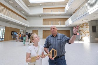 Neue Oberschule am Hartmannplatz in Chemnitz geht an Start - Charlotte Kohl, Schülerin der neuen Schule am Hartmannplatz, und der amtierende Schulleiter Thorsten Noack mit dem großen Schlüssel für das neue Gebäude. Schülerin und Lehrer stehen im Erdgeschoss der Einrichtung.