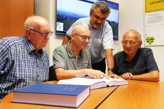 Neue Ortsfamilienbücher für Dittersdorf und Weißbach reichen zurück bis 1501 - Gespannt blicken Weißbachs Ortsvorsteher Günter Müller, Autor Steffen Scholtz, Amtsbergs Bürgermeister Sylvio Krause sowie der Dittersdorfer Ortsvorsteher Eckhard Haase (von links) in die beiden Ortsfamilienbücher.