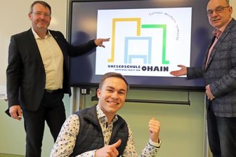Neue Schule - neues Logo - Louis Gerischer (M.) präsentiert gemeinsam mit Freibergs Oberbürgermeister Sven Krüger (l.) und Schulleiter Jens Gernegroß das von ihm entworfene neue Logo der Oberschule "Gottfried Pabst von Ohain".