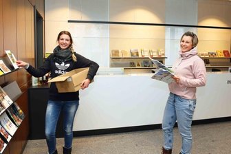 Neue Stadt- und Tourist-Info ab Dienstag im Theater - Die beiden Rathausmitarbeiterinnen Julia Rosenlöcher (links) und Kristin Franke beim Bestücken der Regale mit reichlich Info-Material für Einwohner und Besucher der Großen Kreisstadt.