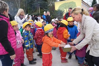 Neue Tagesstätte nimmt (runde) Gestalt an - Bevor die Schatztruhe in der Bodenplatte der künftigen Kita versenkt wurde, legten die Kinder noch selbstgemalte Bilder in die kleine Kiste.