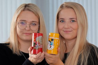 Neue Tasse, teurerer Glühwein und Sicherheit: Was Sie über den Chemnitzer Weihnachtsmarkt 2025 wissen müssen - Kathleen Herold (links) und Lucy Auerbach vom Marktamt präsentieren die neuen Weihnachtsmarkttassen.