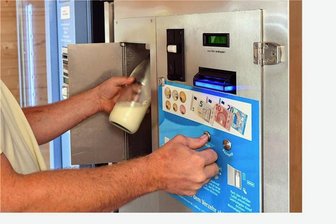 Neuer Ärger für Landwirte: Erneut Milchautomat im Vogtland aufgebrochen - Ein Mann zapft mit einer Flasche frische Rohmilch an einer Milchtankstelle. Es handelt sich um ein Illustrationsbild. Foto: Martin Schutt/dpa