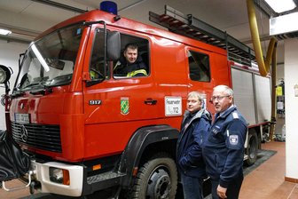 Neuer Amtsberger Feuerwehrbedarfsplan wird heiß diskutiert - Das Löschgruppenfahrzeug, in dem Tilo Lang gerade sitzt, stellt in den Augen von Weißbachs Ortswehrleiter Silvio Richter und Amtsbergs Gemeindewehrleiter Jan Hofmann (rechts) einen Diskussionspunkt dar, da es kein Wasser transportieren kann.