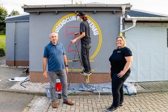 Neuer Anstrich, neues Logo, neue Energie: Jugendclub Frankenau ist bereit für den Dorfabend bei Mittweida - Ingo Gringer (l.) und Anja Weiß (r.) schauen Philipp Kühn von Rebel Art beim Sprayen über die Schulter.