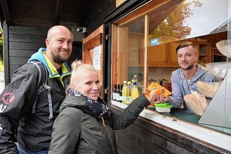 Neuer Betreiber: Imbiss auf der Hohen Reuth in Schöneck wieder offen - Annegret Damerau und Matthias Käsler zählten zu den ersten Gästen am wiedereröffneten Imbiss auf der Hohen Reuth in Schöneck. Lucas Sattler wird im Auftrag des neuen Betreibers dort arbeiten. 