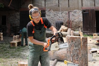 Neuer Kunsthof im Erzgebirge: Wo junge Künstler dem Leben von Hans Brockhage unmittelbar begegnen - Das Aufheulen der Motorsägen durchbricht ab und an die Stille im idyllisch gelegenen Dreiseitenhof in Bermsgrün: Lotte Schwanitz bei der Arbeit.