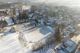 Neuer Parkplatz am Fichtelberg – Oberwiesenthal schaltet Anwälte ein - Vorn die Fläche am Skihang, auf der bis zu 100 Autos Platz finden sollen.