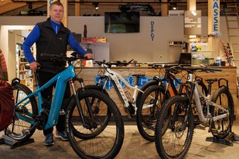 Neuer Plan am Fichtelberg heißt „Bike-Genuss Erzgebirge“ - Zum „Bike-Genuss Erzgebirge“ sollen einheimische Firma wie Sport Gahler aus Oberwiesenthal und die Vielfalt der Fahrradtechnik eine zentrale Rolle spielen. Hier zeigt Verkäufer Matthias Schmiedl ein E-Bike, daneben stehen ein weiteres E-Bike, ein Hardtail-Mountainbike und Kinder-Fully-Bike (v. l.)