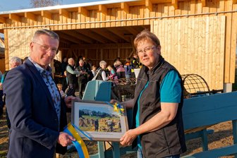 Neuer Platz für alte Landwirtschaftstechnik: Dorfverein Lauta nimmt Scheune in Betrieb - Oberbürgermeister André Heinrich überreicht zur Scheuneneinweihung Ramona Fritzsche, Vorsitzende des Dorfvereins, ein historisches Bild von Lauta.