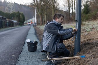 Neuer Radweg im Erzgebirge: Eröffnungsfeier nun doch erst im Frühjahr - Am neuen Radweg sind nur noch Restarbeiten zu erledigen. Im Bild Rico Hofmann von der Firma Steffen Grimm bei der Installation der Beleuchtung in Höhe der Gartenanlage in Herold.