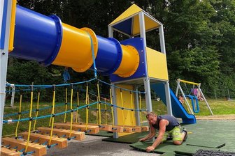 Neuer Spielplatz im Muldabad fast fertig - Ein neuer Spielplatz für Kinder entsteht im Erlebnisbad Mulda.Mitte Juli verlegte Marco Reuter (Foto), Mitarbeiter im Unternehmen Spiel Spaß Freizeit Klaus Krieh aus Sayda, gerade Fallschutz-Platten. Zur Spielburg gehören zwei Türme, zwei Rutschen, ein Tunnel und eine Hängebrücke. In den nächsten Wochen soll die Spielburg fertig gestellt werden. Auch eine extra Schaukel wurde aufgebaut. Nach der Abnahme durch den Tüv soll der Spielplatz laut Schwimmmeister Roy Aumann sofort von den Kindern in Besitz genommen werden können.https://www.erlebnisbad-mulda.de/