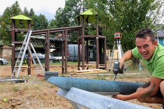 Neuer Spielplatz in Raschau nimmt sichtbar Gestalt an - Steffen Mücke schraubt am Gestell für die Schaukel.